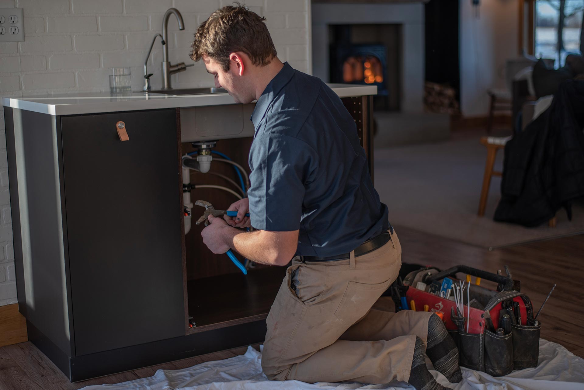 Riser Plumber fixing a residential plumbing issue in a home. 